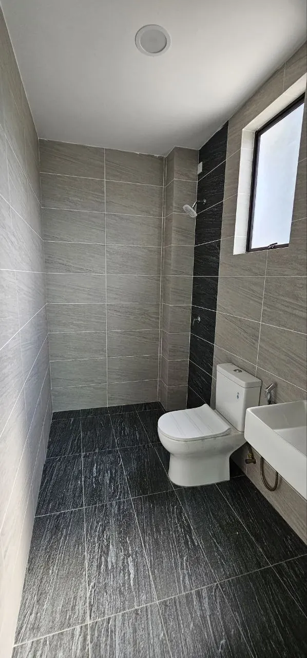 Bathroom of the Ampang Cove terrace unit, tiled floor to ceiling